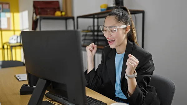 年轻美丽的他的惊慌失措的女商人在办公室用笔记本电脑和赢家的表情一起工作 — 图库照片