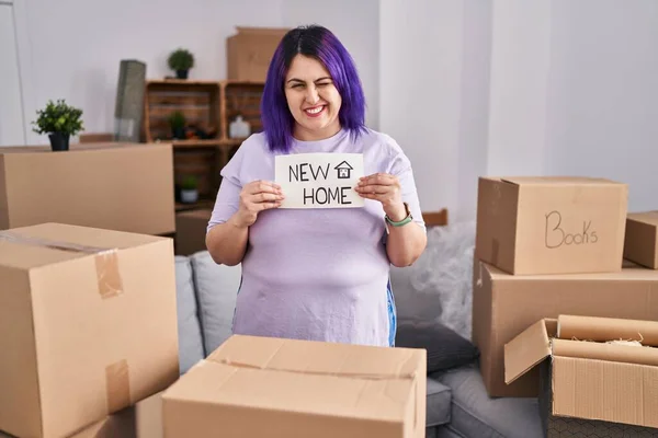 另外一个身材魁梧的女人带着紫色的头发 举着横幅 带着性感的表情 开朗而快乐地看着摄像机 走向一个新家 — 图库照片