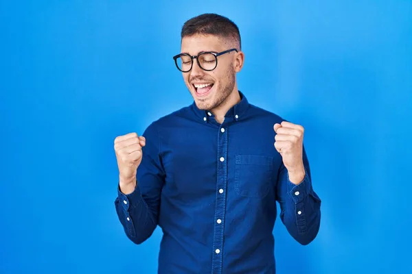 Mavi Arka Planda Gözlüklü Genç Spanyol Adam Çok Mutlu Heyecanlı — Stok fotoğraf