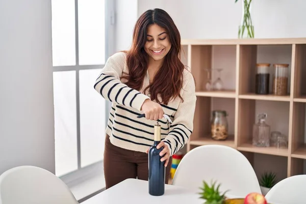 Young Hispanic Woman Smiling Confident Uncorking Red Wine Bottle Home — Foto Stock