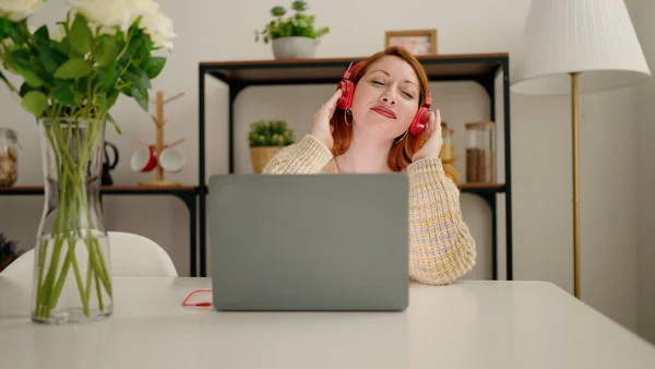 Νεαρή Κοκκινομάλλα Γυναίκα Που Ακούει Μουσική Κάθεται Στο Γραφείο Στο — Φωτογραφία Αρχείου