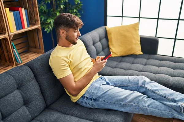 Young Arab Man Using Smartphone Sitting Sofa Home — Fotografia de Stock