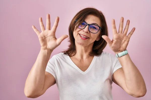 Middelbare Leeftijd Spaanse Vrouw Staan Roze Achtergrond Tonen Wijzen Met — Stockfoto