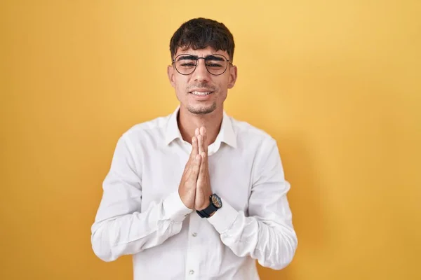 Homem Hispânico Jovem Sobre Fundo Amarelo Implorando Orando Com Mãos — Fotografia de Stock