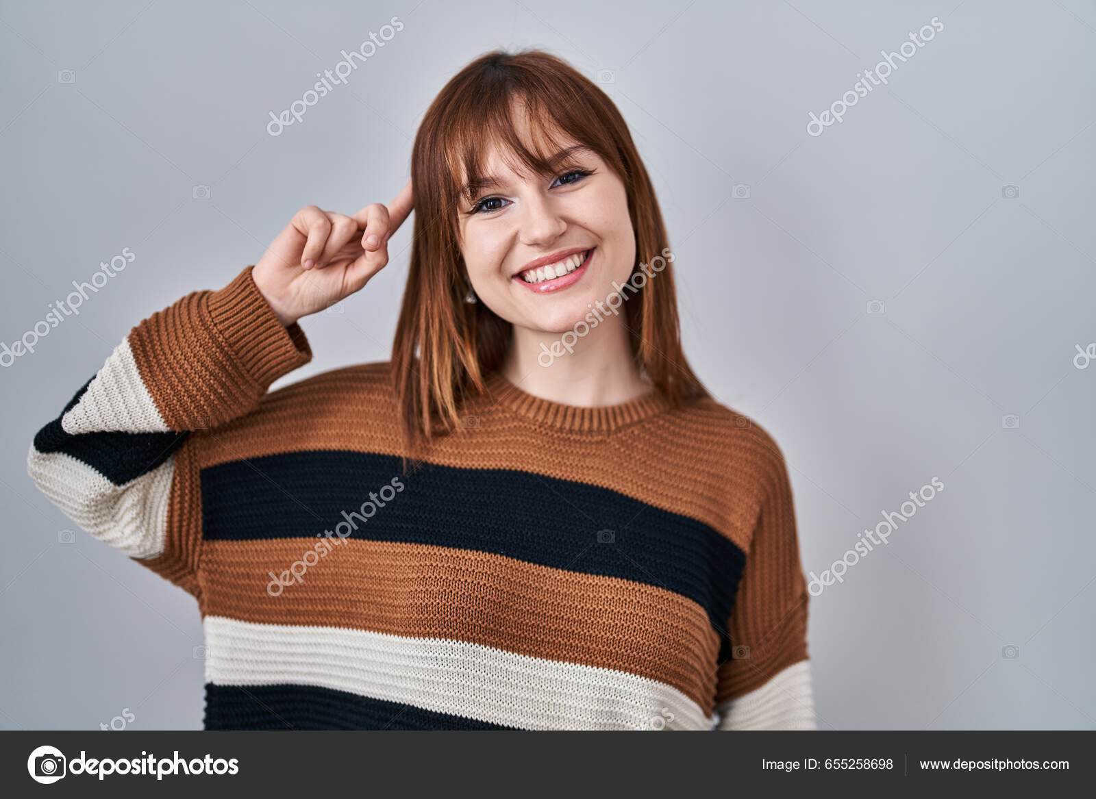 Descarregar - Jovem mulher bonita vestindo camisola listrada sobre fundo isolado sorrindo apontando para a cabeça com um dedo, ótima ideia ou pensamento, boa memória — Imagem de Stock Jovem Mulher Bonita Vestindo Camisola Listrada Sobre Fundo Isolado Sorrindo — Fotografia de Stock