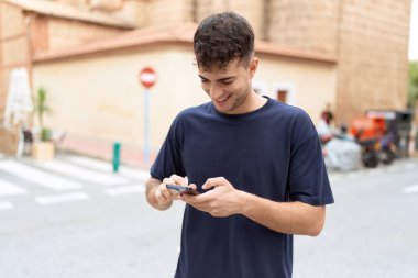 Sokakta akıllı telefon kullanan, kendine güvenen genç bir İspanyol.
