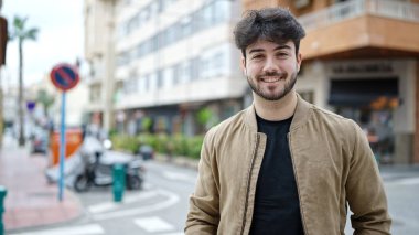 Sokakta kendinden emin gülümseyen İspanyol genç adam.