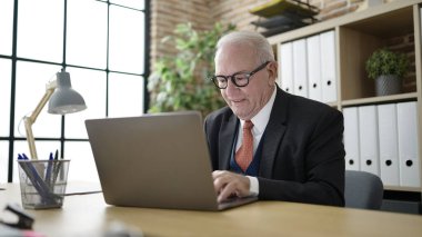 Ofiste dizüstü bilgisayarla çalışan bir iş adamı.