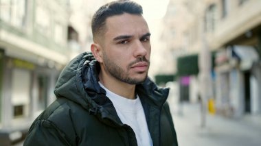 Sokakta ciddi bir ifadeyle duran İspanyol genç adam.