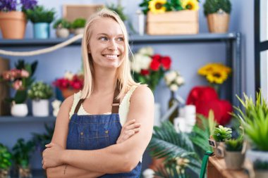 Young blonde woman florist smiling confident standing with arms crossed gesture at florist store