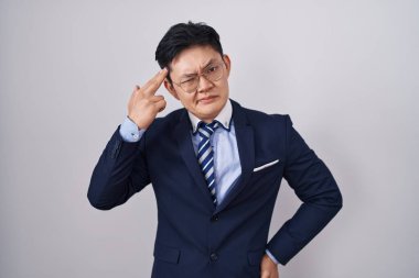 Genç Asyalı takım elbiseli ve kravatlı bir adam kendini vuruyor ve öldürüyor. Kendini ve parmaklarını silah gibi gösteriyor. İntihar hareketi.. 