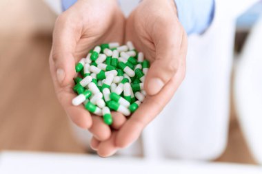 Eczanede ilaç tutan genç İspanyol bir eczacı.