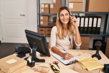 Genç sarışın kadın ecommerce iş çağrı merkezi ajanı ofiste çalışıyor.
