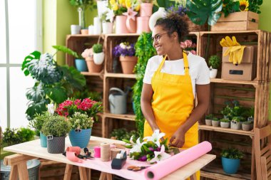 African american woman florist make bouquet of flowers at flower shop