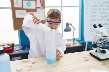 Sevimli İspanyol öğrenci laboratuvar sınıfında kendine güvenen bir öğrenci test tüpüne sıvı döküyor.