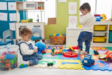 Anaokulunda oynayan sevimli kız ve oğlan.