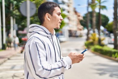 Young man using smartphone at street