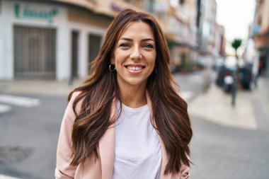 Sokakta kendine güvenen genç İspanyol kadın gülümsüyor