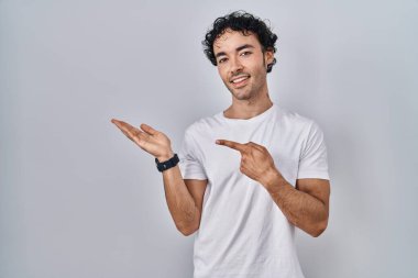 İzole edilmiş arka planda duran İspanyol adam kameraya hayret ediyor ve gülümsüyor.. 