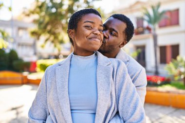 Kadın ve erkek parkta birbirlerine sarılıyorlar.