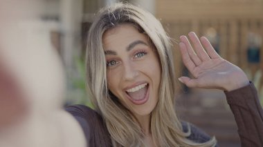 Genç sarışın kadın gülümsüyor. Kendine güveni tam.