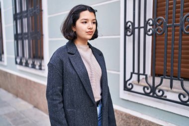 Young woman looking to the side with relaxed expression at street