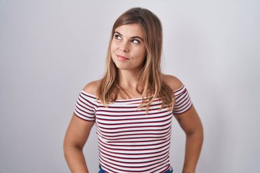 Soyutlanmış arka planda duran genç İspanyol kadın gülümseyip yan tarafa bakıyor ve düşünüyor.. 