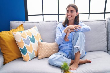 Evdeki kanepede oturan kendine güvenen güzel İspanyol kadın.