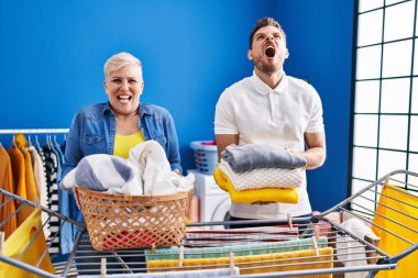İspanyol anne ve oğlu çamaşır ipine kıyafet asıyor kızgın ve kızgın çığlıklar atıyor öfkeyle bağırıyor, öfkeyle yukarı bakıyor.. 