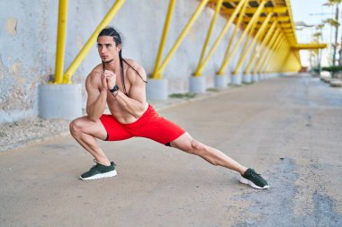Young man stretching legs at street