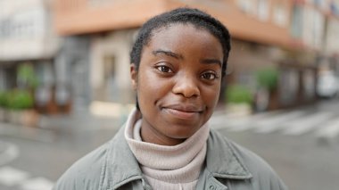 Sokakta rahat bir ifadeyle dikilen Afrikalı Amerikalı kadın.