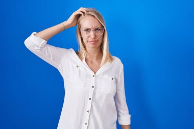 Mavi arka planda dikilen beyaz bir kadın soru sorup kafasını karıştırıyor. Şüpheyle kararsız, kafa kafaya düşünerek. Düşünceli kavram. 