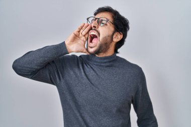 Yakışıklı Latin adam izole edilmiş arka planda durup el pençe divan durup bağırıyor. iletişim konsepti. 