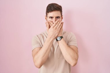 Pembe arka planda duran İspanyol sakallı adam yanlışlıkla ağzı ellerle kapatırken şok oldu. gizli kavram. 