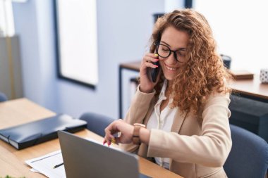 Genç, güzel İspanyol kadın iş adamı. Akıllı telefondan konuşuyor. Ofiste nöbet tutuyor.