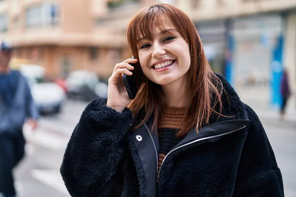 若い女性が自信を持って路上でスマートフォンで話して笑っている — ストック写真