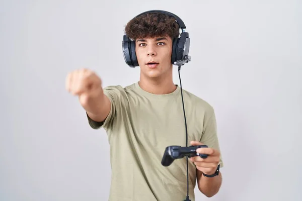 Hispanic Teenager Playing Video Game Holding Controller Pointing Finger Surprised — Stock Photo, Image