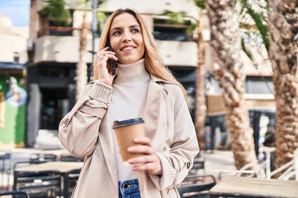 여자가 스마트폰으로 커피숍 테라스에서 커피를 마시고 있습니다 — 스톡 사진