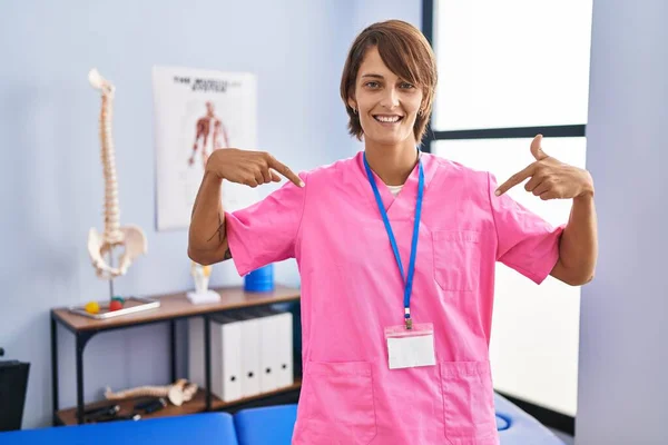 Brunette Woman Working Rehabilitation Clinic Looking Confident Smile Face Pointing — Stock Photo, Image