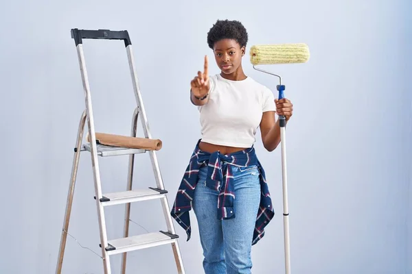 Africano Americano Mulher Segurando Pintor Rolos Apontando Com Dedo Para — Fotografia de Stock