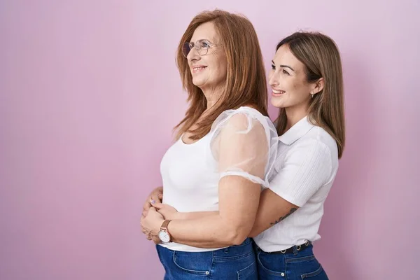 西班牙裔母亲和女儿穿着宽松的白色T恤 背景粉红 面容自然 面带微笑 放松自己 — 图库照片