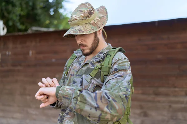 Asker üniforması giyen İspanyol genç adam parkı gözetliyor.