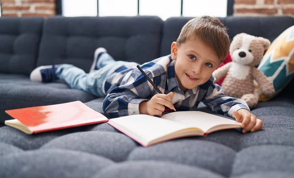 Adorável Caucasiano Menino Estudante Escrevendo Caderno Deitado Sofá Casa — Fotografia de Stock