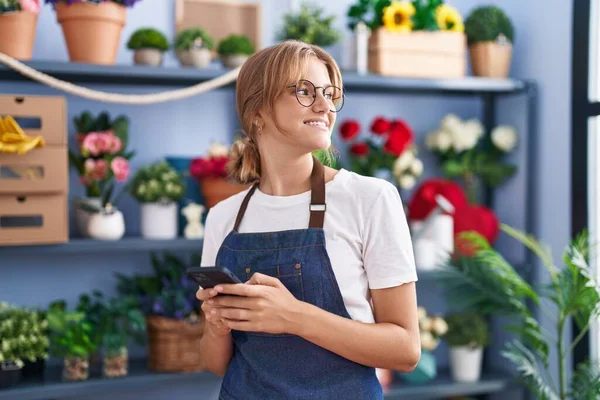 Joven Florista Chica Rubia Sonriendo Confiado Usando Teléfono Inteligente Floristería — Foto de Stock