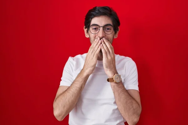 Young Hispanic Man Standing Red Background Laughing Embarrassed Giggle Covering — Stockfoto