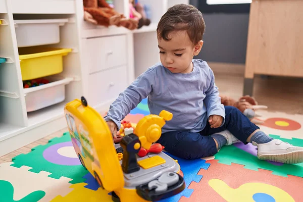 可敬的他的惊慌失措的孩子在幼儿园的地板上玩工具玩具 — 图库照片