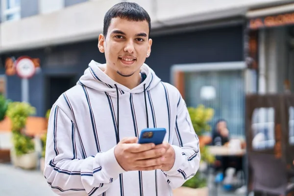Junger Mann Lächelt Selbstbewusst Mit Smartphone Auf Der Straße — Stockfoto