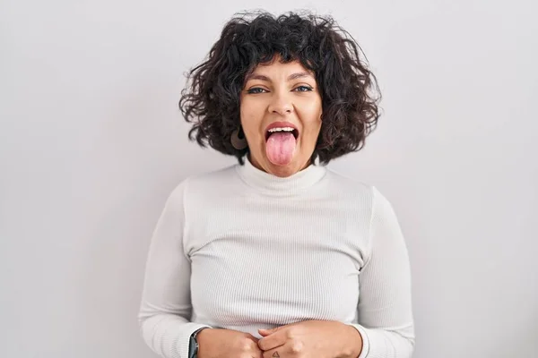 変な表情で幸せを舌を突き出す孤立した背景の上に立って巻き毛を持つヒスパニック系の女性 感情の概念 — ストック写真