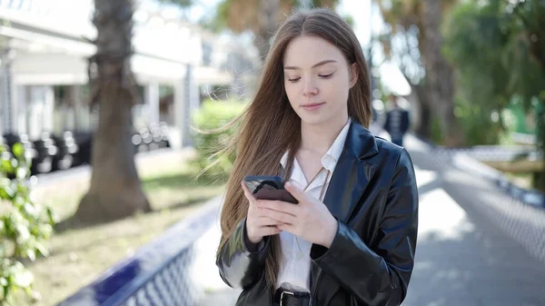 Νεαρή Ξανθιά Γυναίκα Που Χρησιμοποιεί Smartphone Σοβαρή Έκφραση Στο Πάρκο — Φωτογραφία Αρχείου