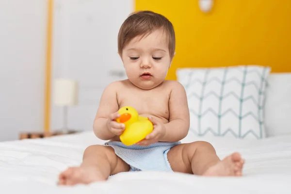 Beyaz Bebek Yatakta Oturmuş Yatak Odasında Ördek Oyuncağıyla Oynuyor — Stok fotoğraf